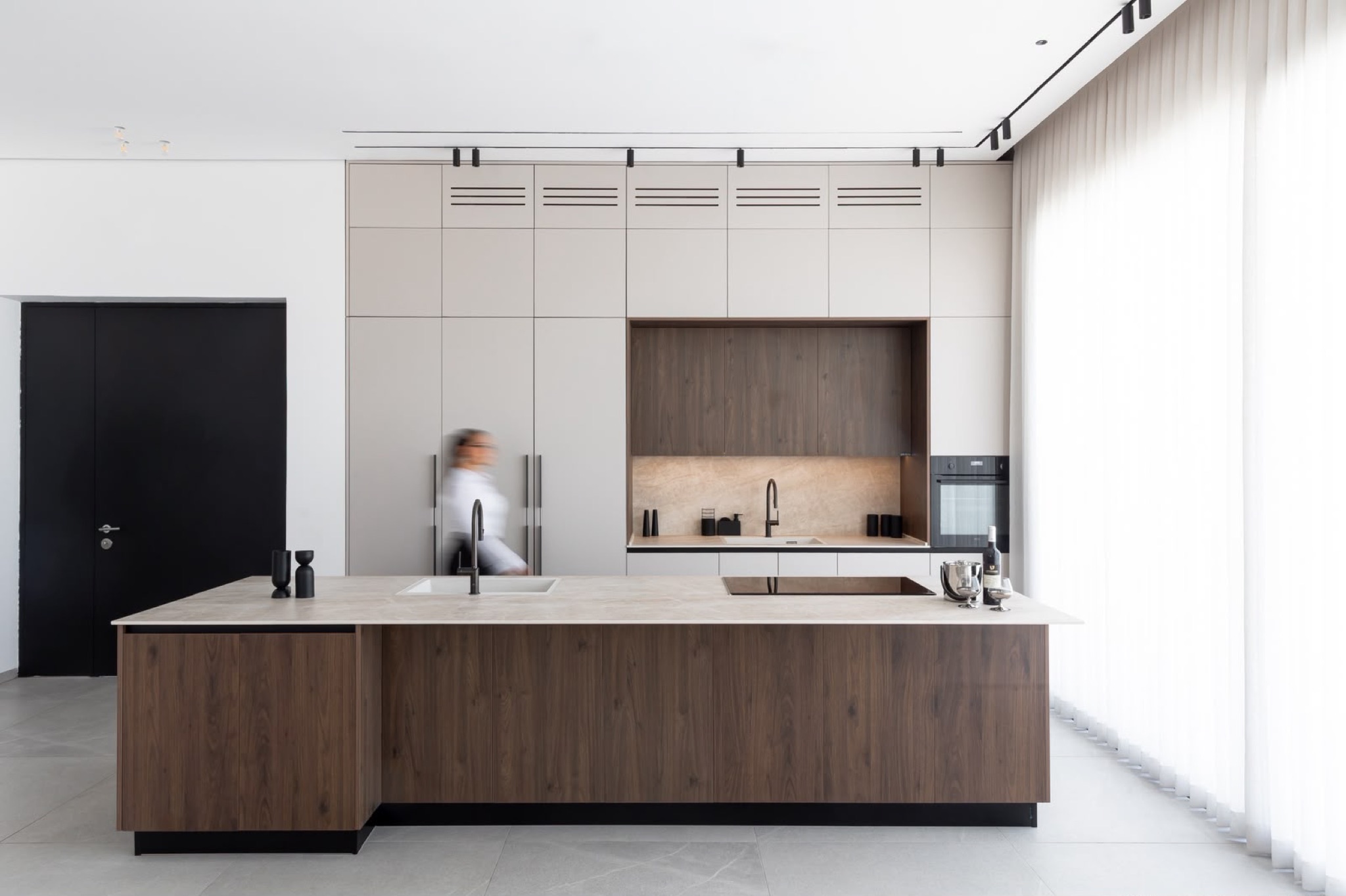 Detail of the walnut base units beneath the pale stone worktop